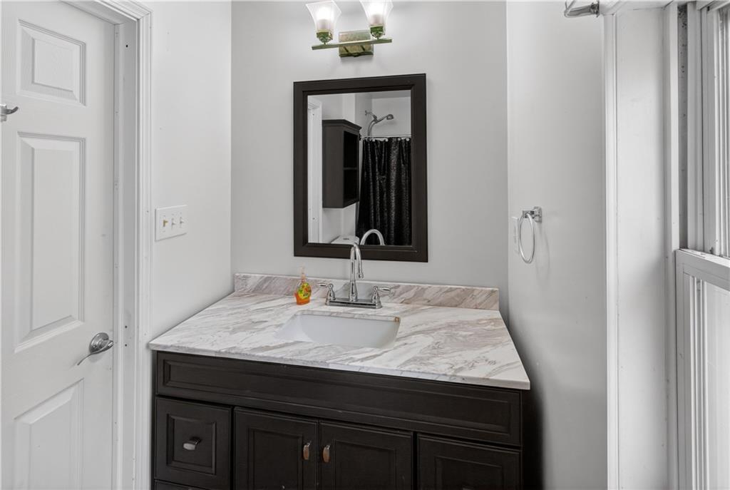 221 Hartzell School Road Fombell, PA 16123 - Photo 27 of 40 a bathroom with a granite countertop sink and a mirror