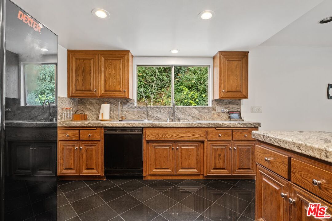 3135 Chandelle Road Los Angeles, CA 90046 - Photo 14 of 29 a kitchen with granite countertop a refrigerator sink and cabinets