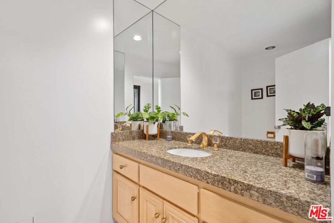3135 Chandelle Road Los Angeles, CA 90046 - Photo 17 of 29 a bathroom with a granite countertop sink and a mirror