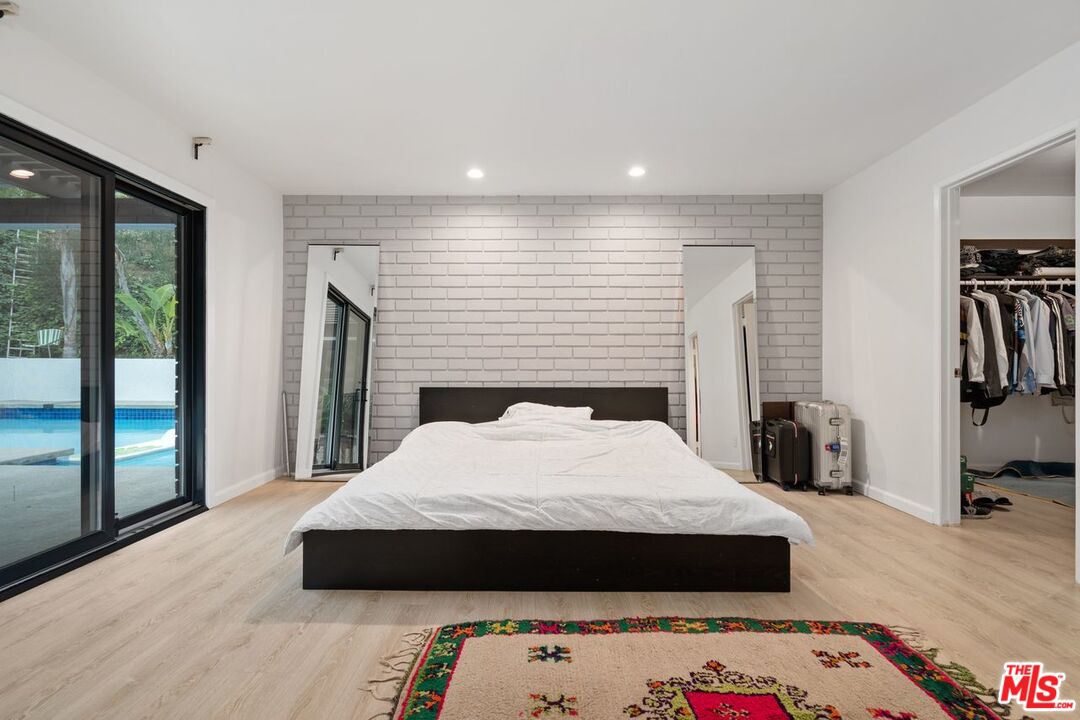 3135 Chandelle Road Los Angeles, CA 90046 - Photo 19 of 29 a large bedroom with a bed and wooden floor