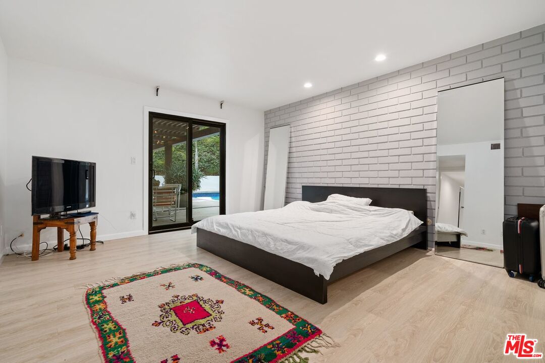 3135 Chandelle Road Los Angeles, CA 90046 - Photo 20 of 29 a spacious bedroom with a bed and a flat screen tv