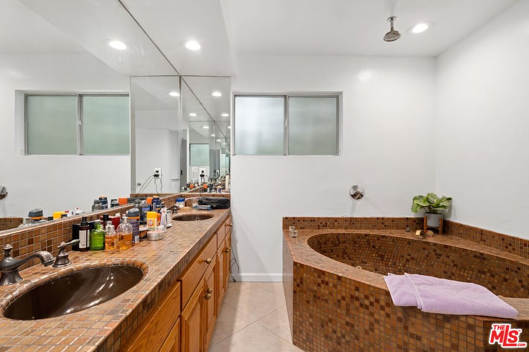 3135 Chandelle Road Los Angeles, CA 90046 - Photo 22 of 29 a bathroom with a granite countertop sink a bathtub a mirror and vanity