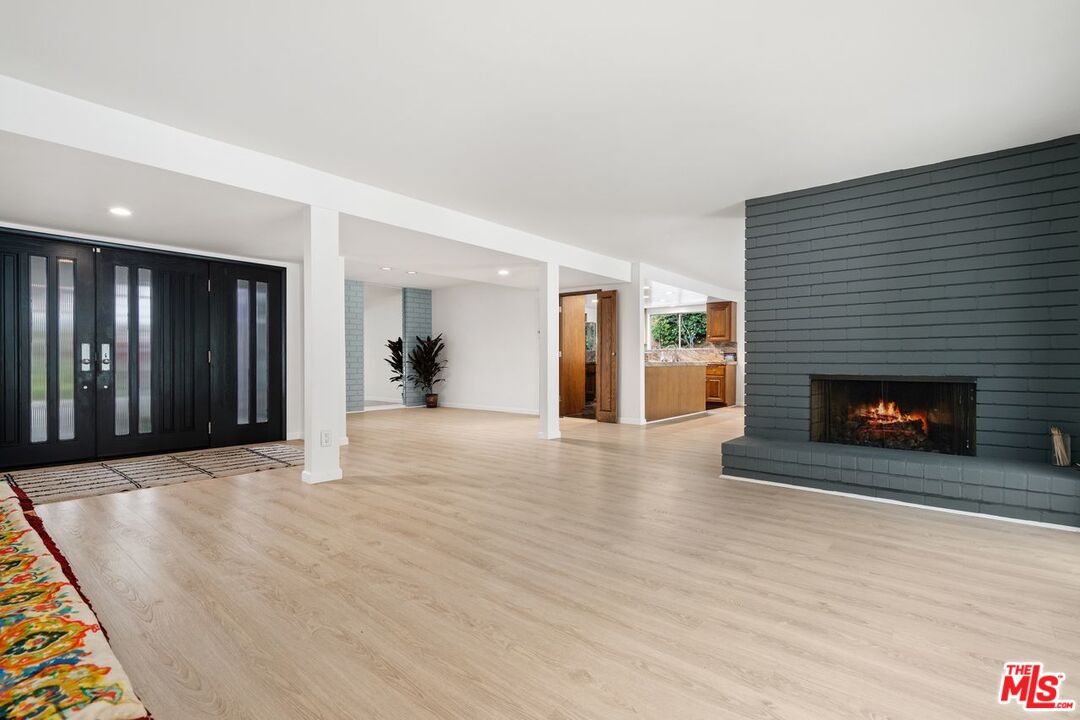 3135 Chandelle Road Los Angeles, CA 90046 - Photo 7 of 29 a view of an empty room with wooden floor fireplace and a window