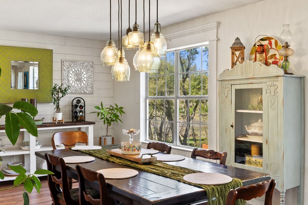 290 Sunset Ridge Dripping Springs, TX 78620 - Photo 19 of 36 A well-lit dining area offers a glimpse of the surrounding greenery through a large multi-pane window.