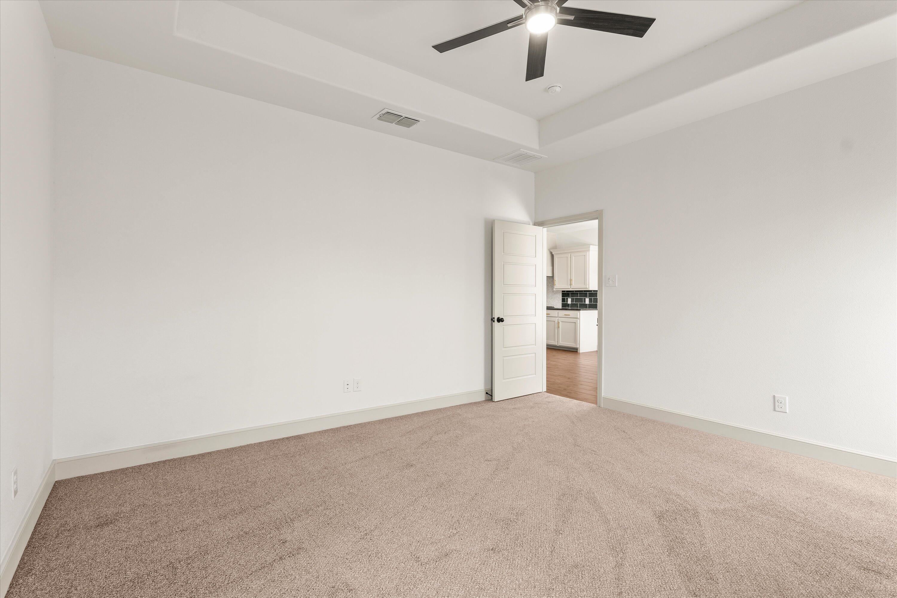 5719 116th Street Lubbock, TX 79424 - Photo 13 of 31 an empty room with a ceiling fan and carpet