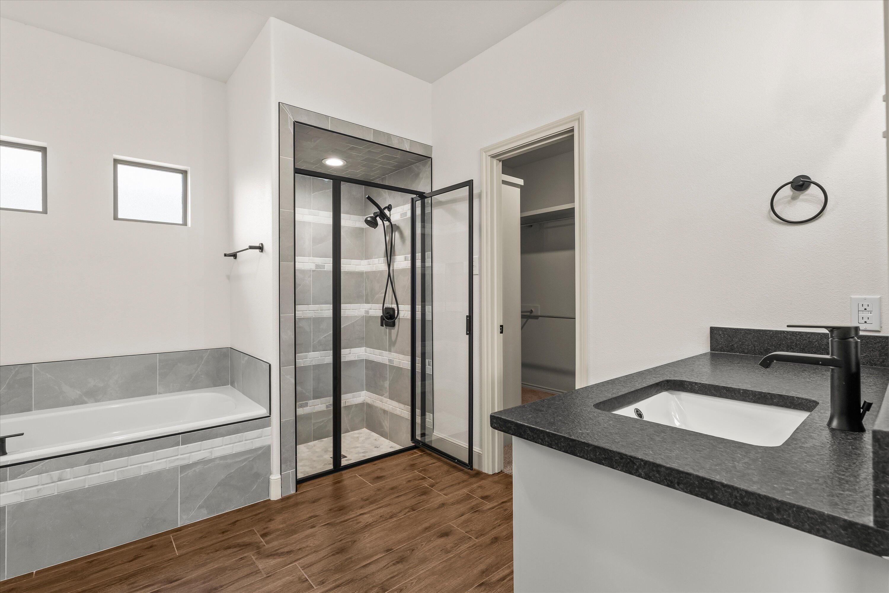 5719 116th Street Lubbock, TX 79424 - Photo 16 of 31 a bathroom with a granite countertop sink and a bathtub