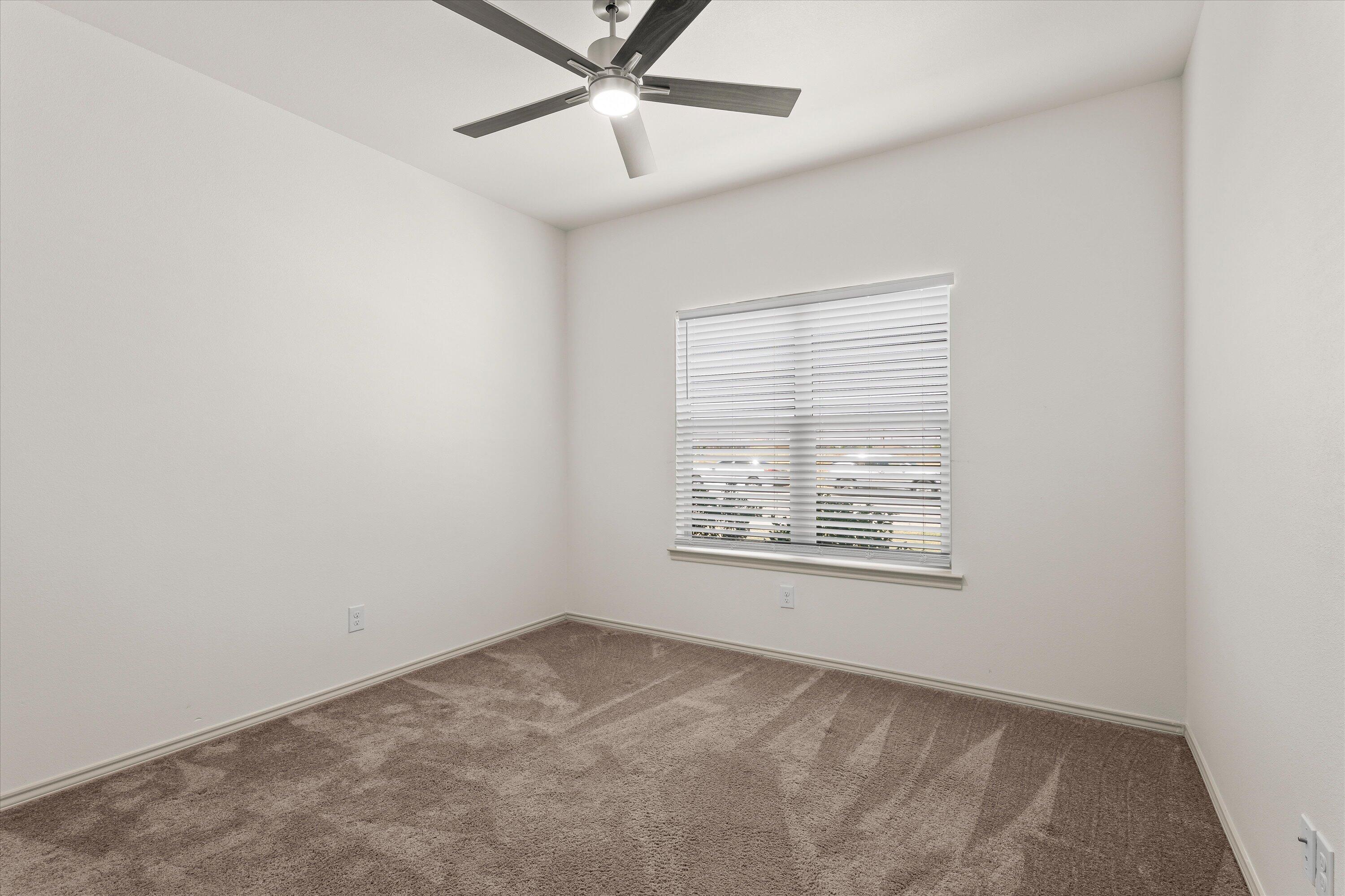 5719 116th Street Lubbock, TX 79424 - Photo 19 of 31 an empty room with a window and a fan