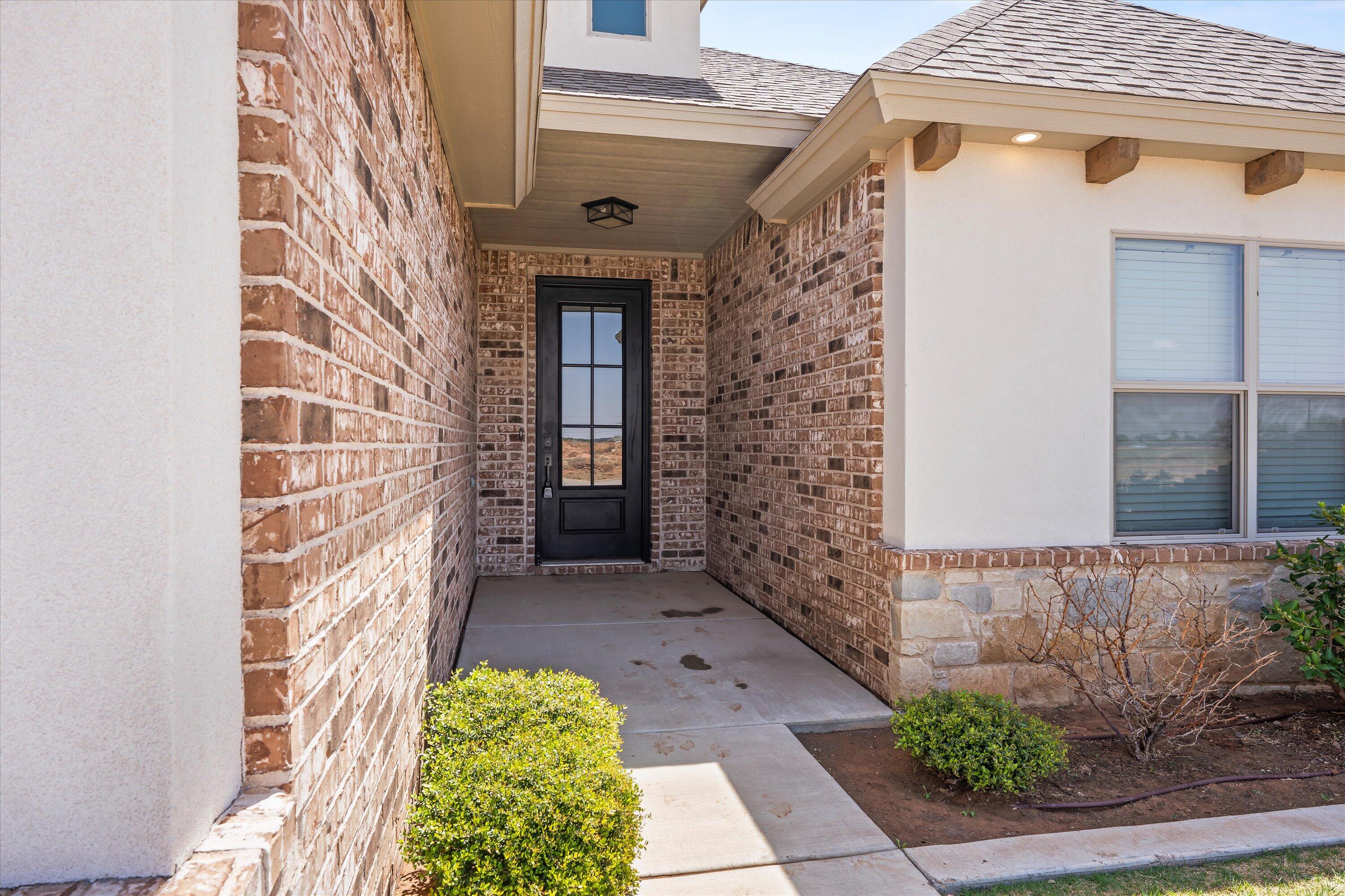 5719 116th Street Lubbock, TX 79424 - Photo 2 of 31 a view of a brick house with a large windows
