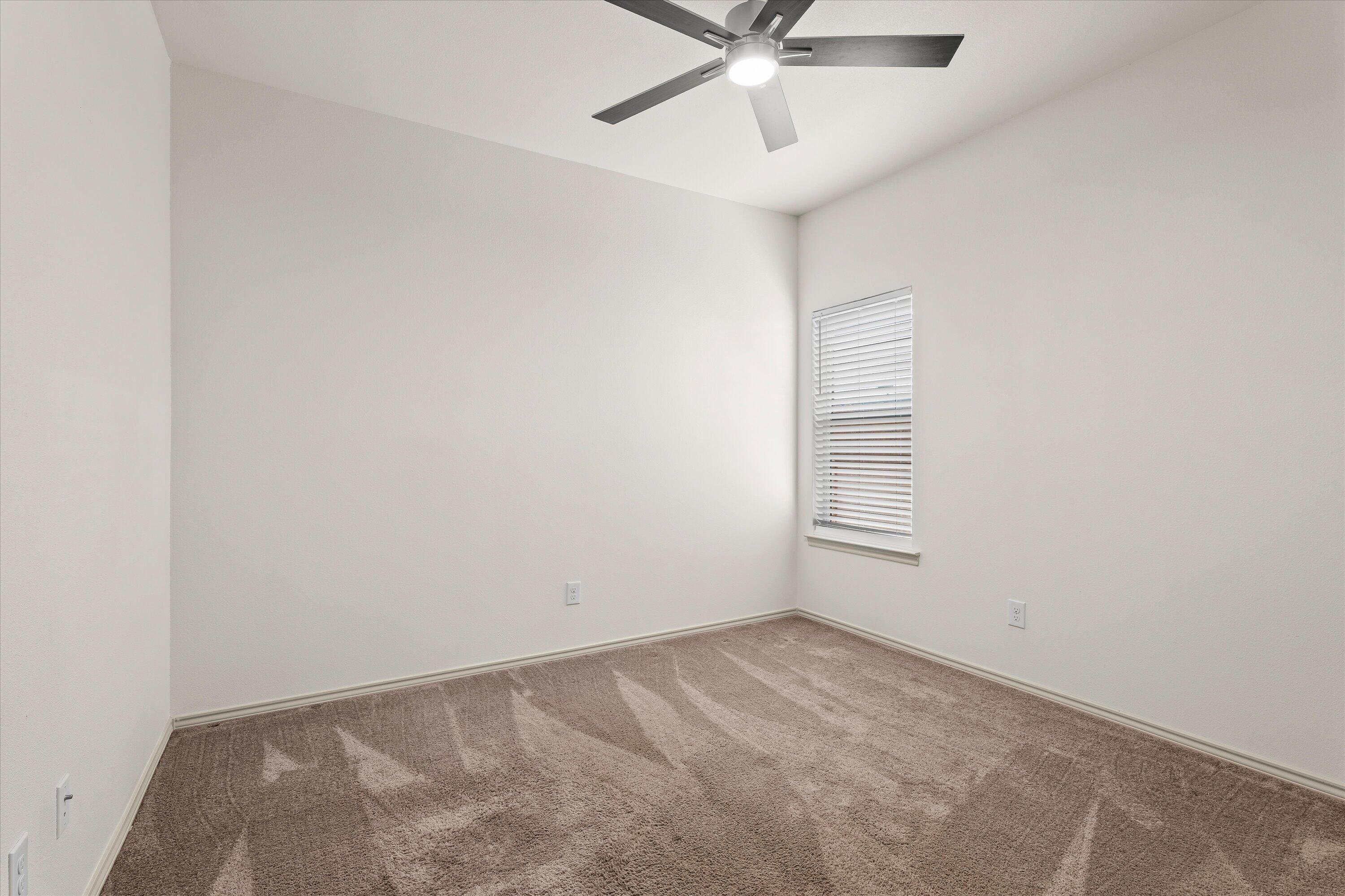 5719 116th Street Lubbock, TX 79424 - Photo 23 of 31 an empty room with a window and a fan