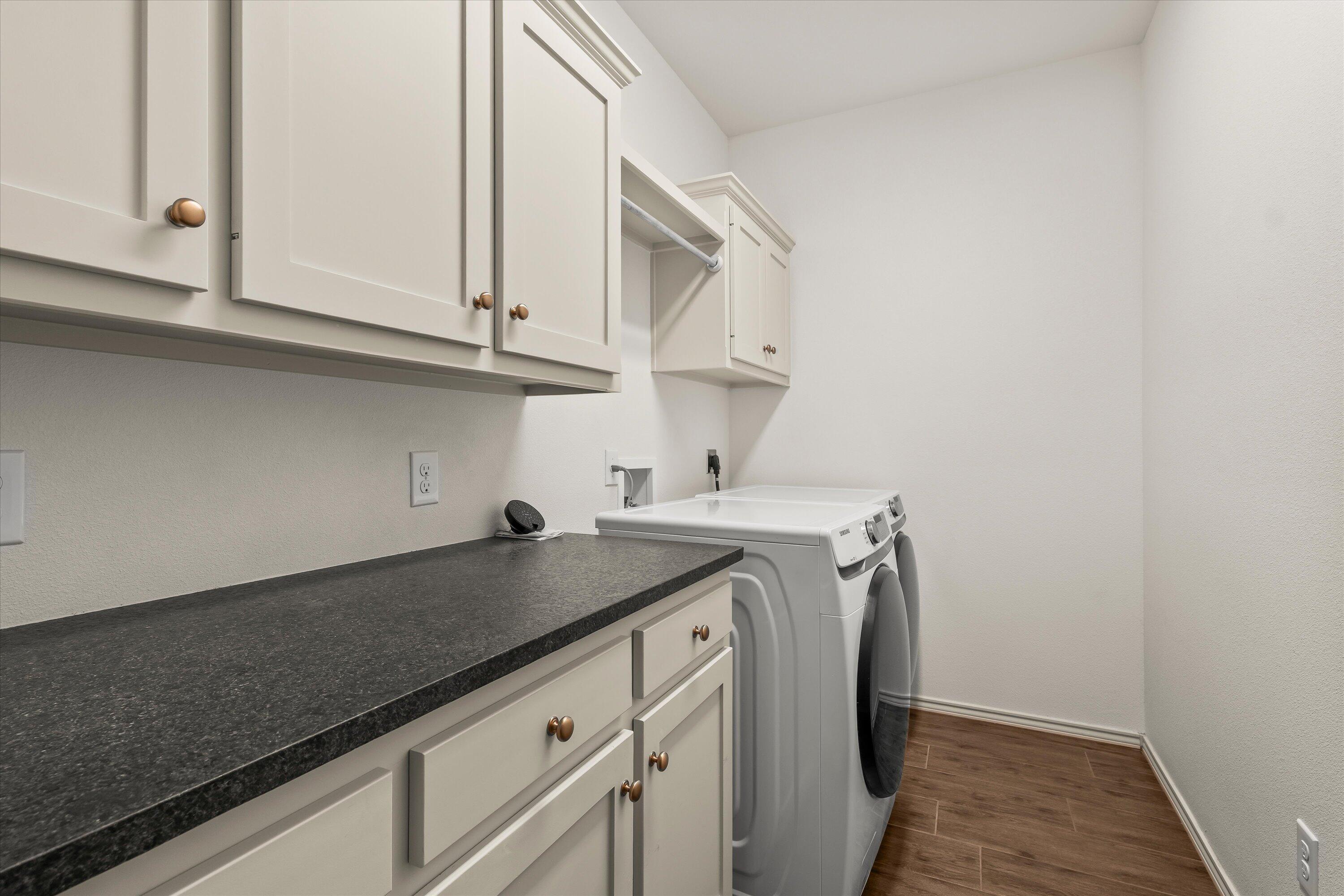 5719 116th Street Lubbock, TX 79424 - Photo 25 of 31 a utility room with granite countertop cabinets washer and dryer