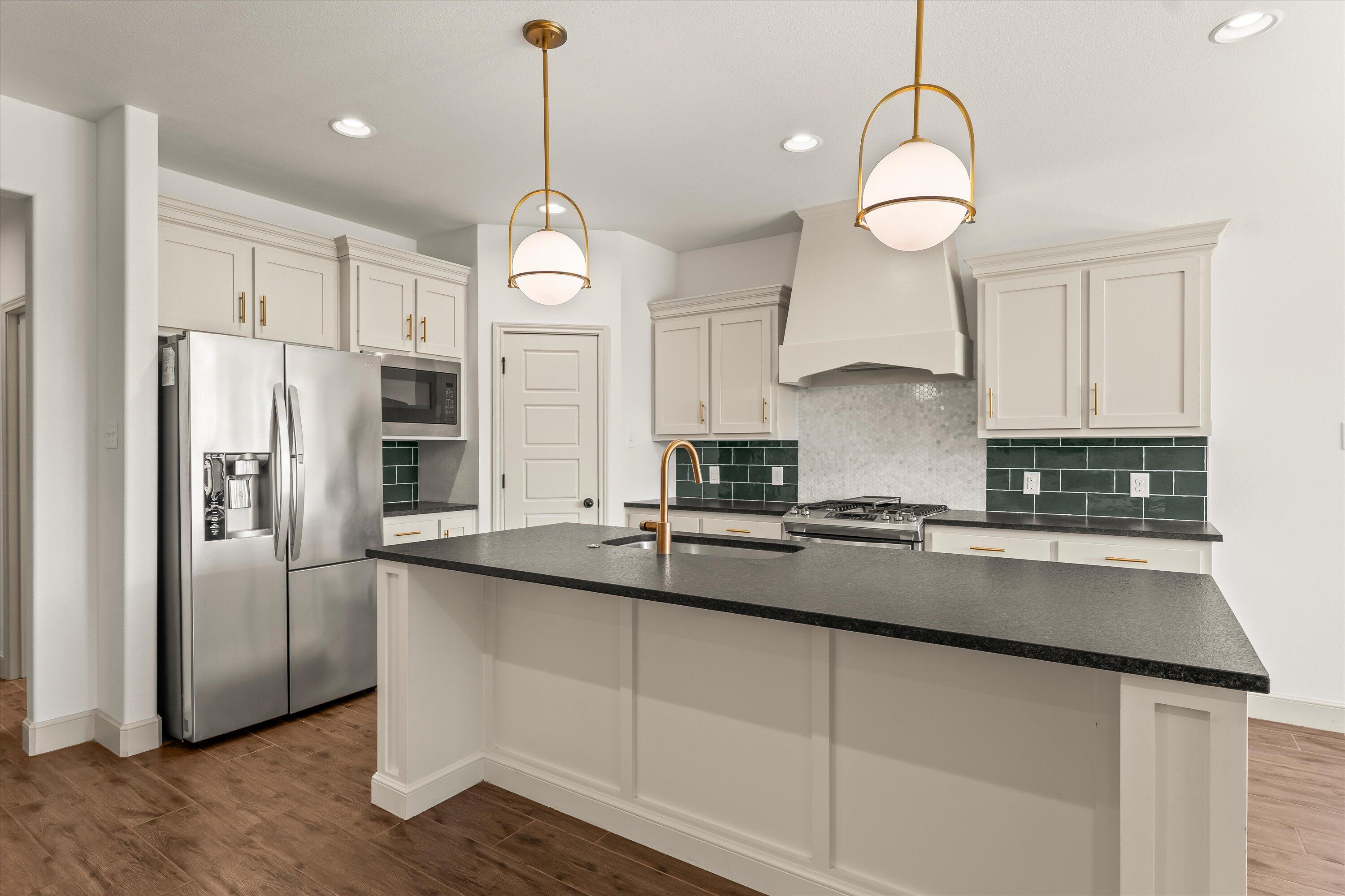 5719 116th Street Lubbock, TX 79424 - Photo 8 of 31 a kitchen with stainless steel appliances a sink a refrigerator center island and cabinets