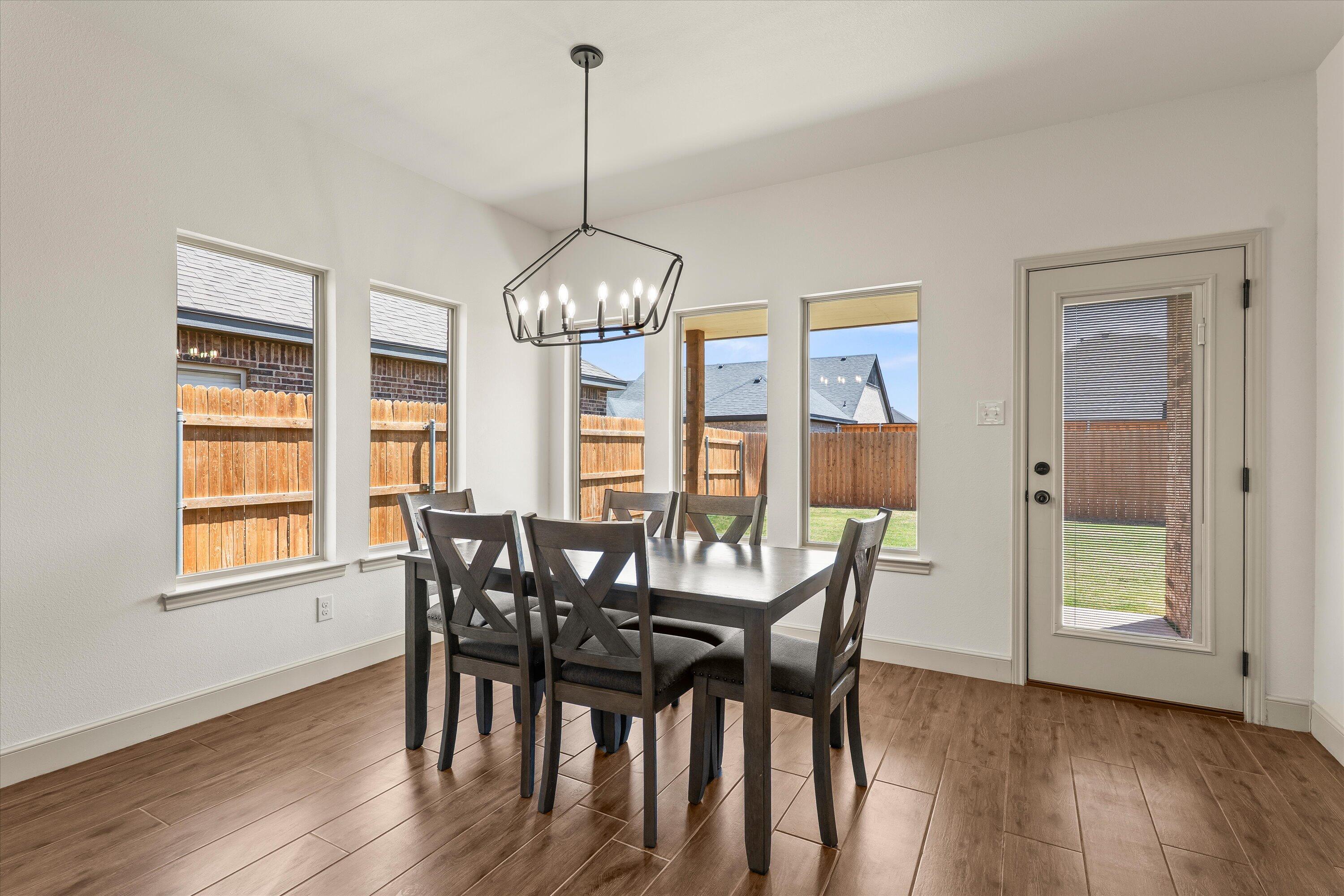 5719 116th Street Lubbock, TX 79424 - Photo 10 of 31 a view of a dining room with furniture window and wooden floor