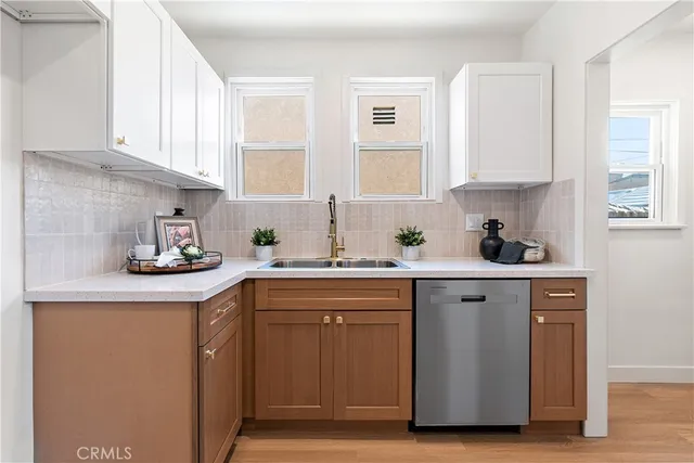 a kitchen with white cabinets and stainless steel appliances