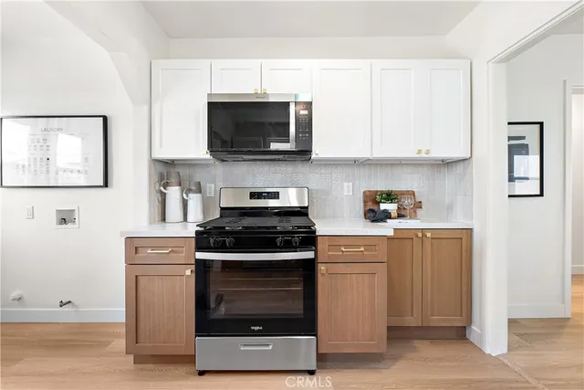 a kitchen with a sink dishwasher a refrigerator and a stove with wooden floor