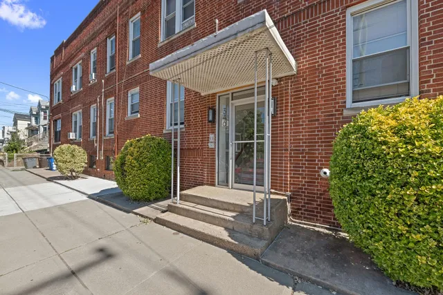 a view of a brick house with potted plants