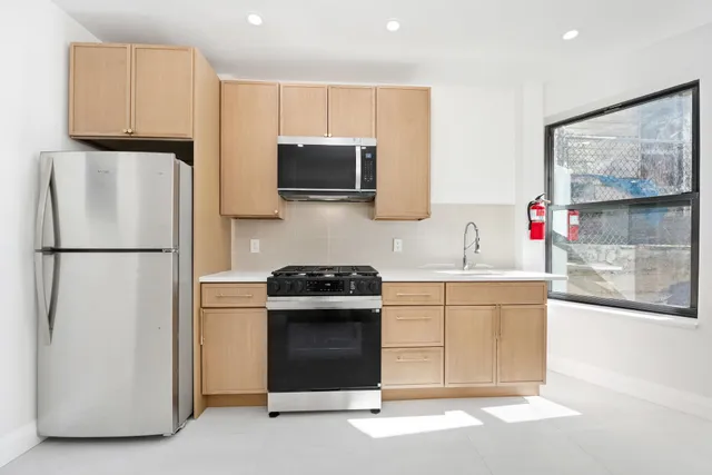 a kitchen with stainless steel appliances granite countertop a refrigerator sink and stove