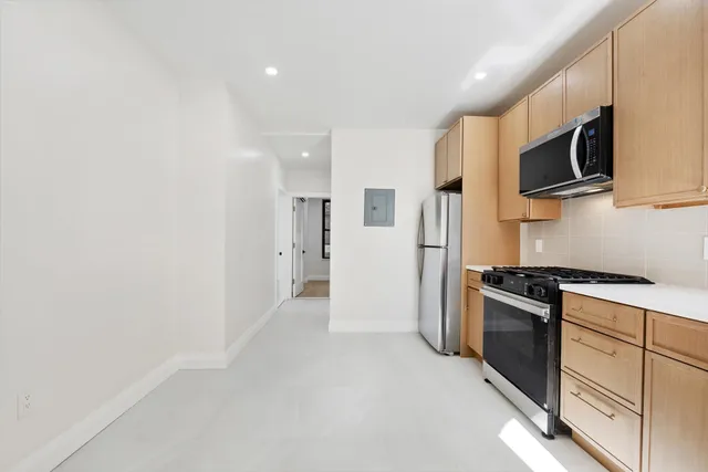 a kitchen with stainless steel appliances granite countertop a refrigerator and a stove top oven