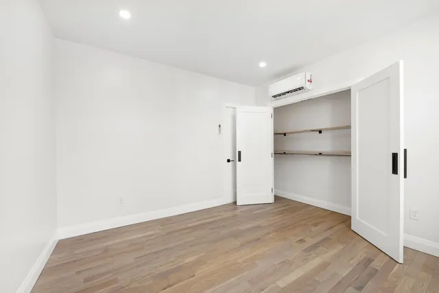 a view of empty room with wooden floor
