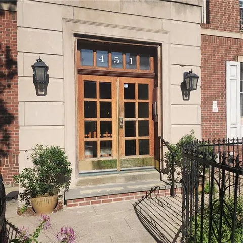 a view of a building with a window and potted plants