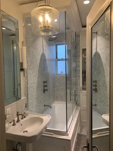 a bathroom with a sink shower and a mirror