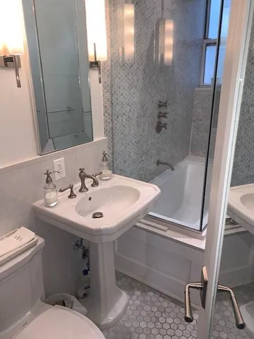 a bathroom with a sink toilet and shower