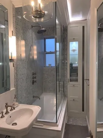 a bathroom with a sink shower and a mirror