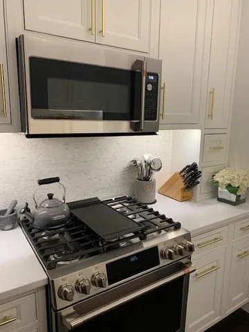 a stove top oven sitting inside of a kitchen