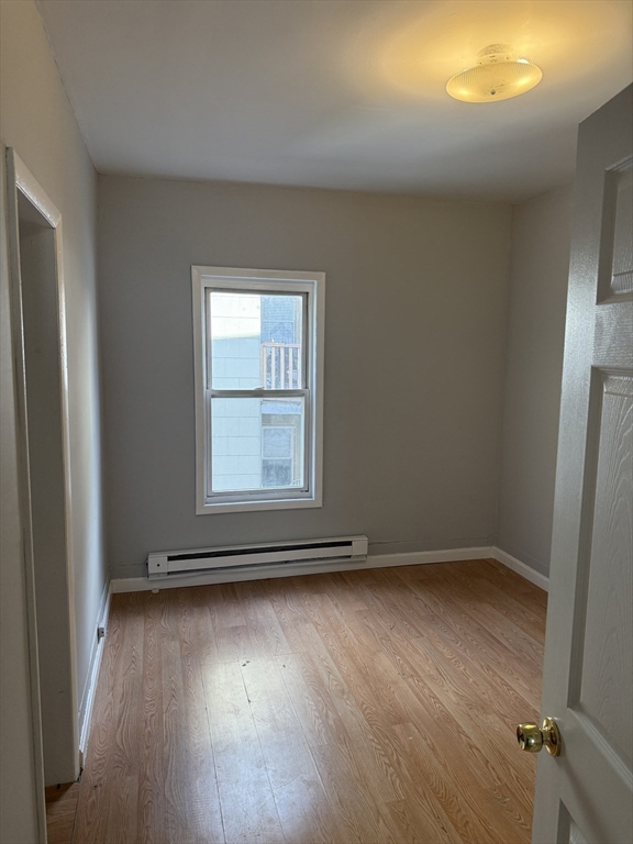 218 Vernon Street, Unit 2 Worcester, MA 01607 - Photo 12 of 19 an empty room with wooden floor and windows