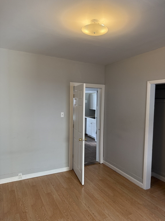 218 Vernon Street, Unit 2 Worcester, MA 01607 - Photo 13 of 19 an empty room with wooden floor and windows