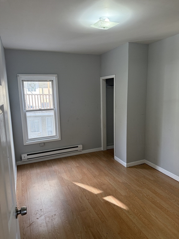 218 Vernon Street, Unit 2 Worcester, MA 01607 - Photo 15 of 19 an empty room with wooden floor and windows