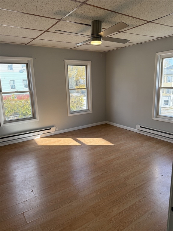 218 Vernon Street, Unit 2 Worcester, MA 01607 - Photo 6 of 19 an empty room with wooden floor fan and windows