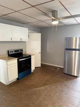 a kitchen with a refrigerator a stove top oven and cabinets