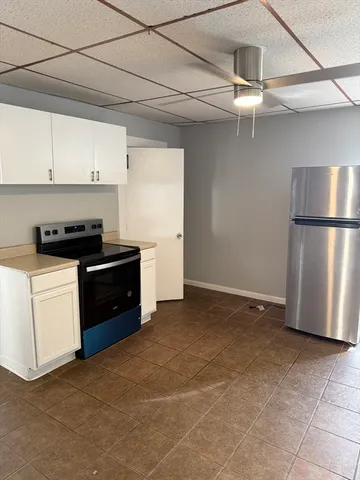 a kitchen with a refrigerator a stove top oven and cabinets