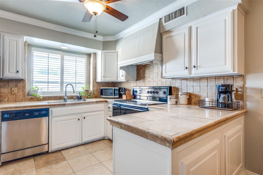 6353 Diamond Head Circle, Unit D Dallas, TX 75225 - Photo 11 of 25 a kitchen with granite countertop a center island a counter space a sink stainless steel appliances and cabinets