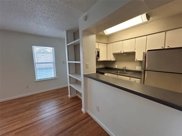 a kitchen with granite countertop a refrigerator and a stove top oven