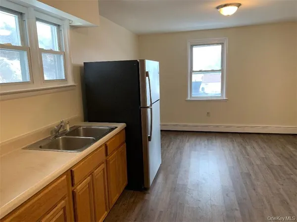 a kitchen with a sink and wooden floor