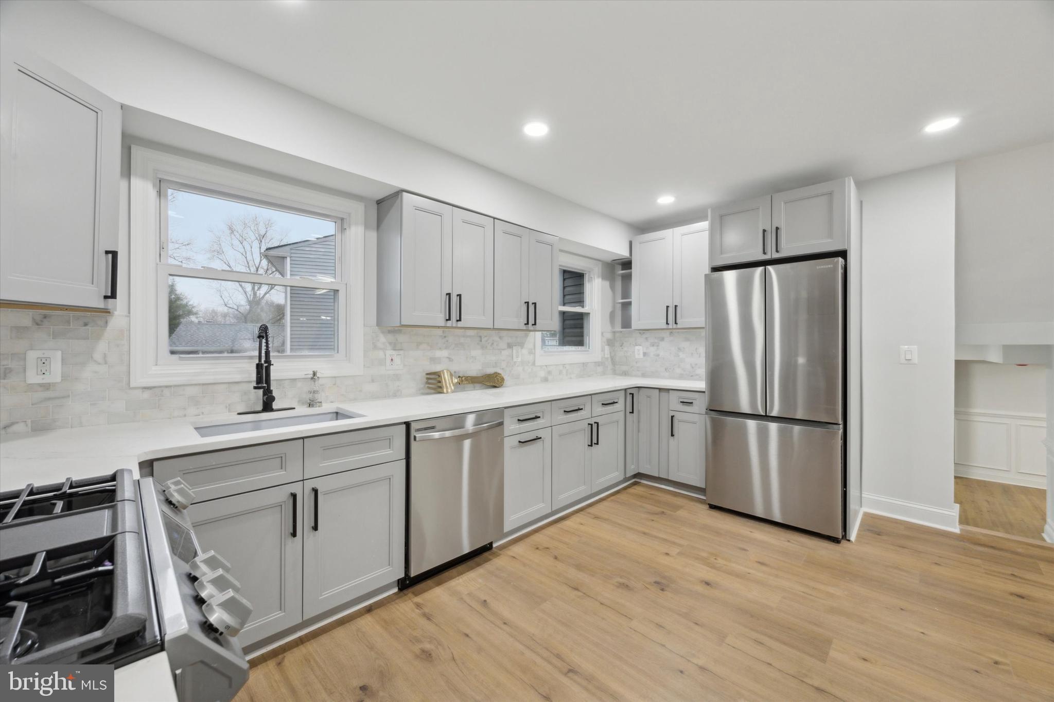 2124 Arleigh Road Cinnaminson, NJ 08077 - Photo 8 of 31 a kitchen with a sink a refrigerator and white cabinets