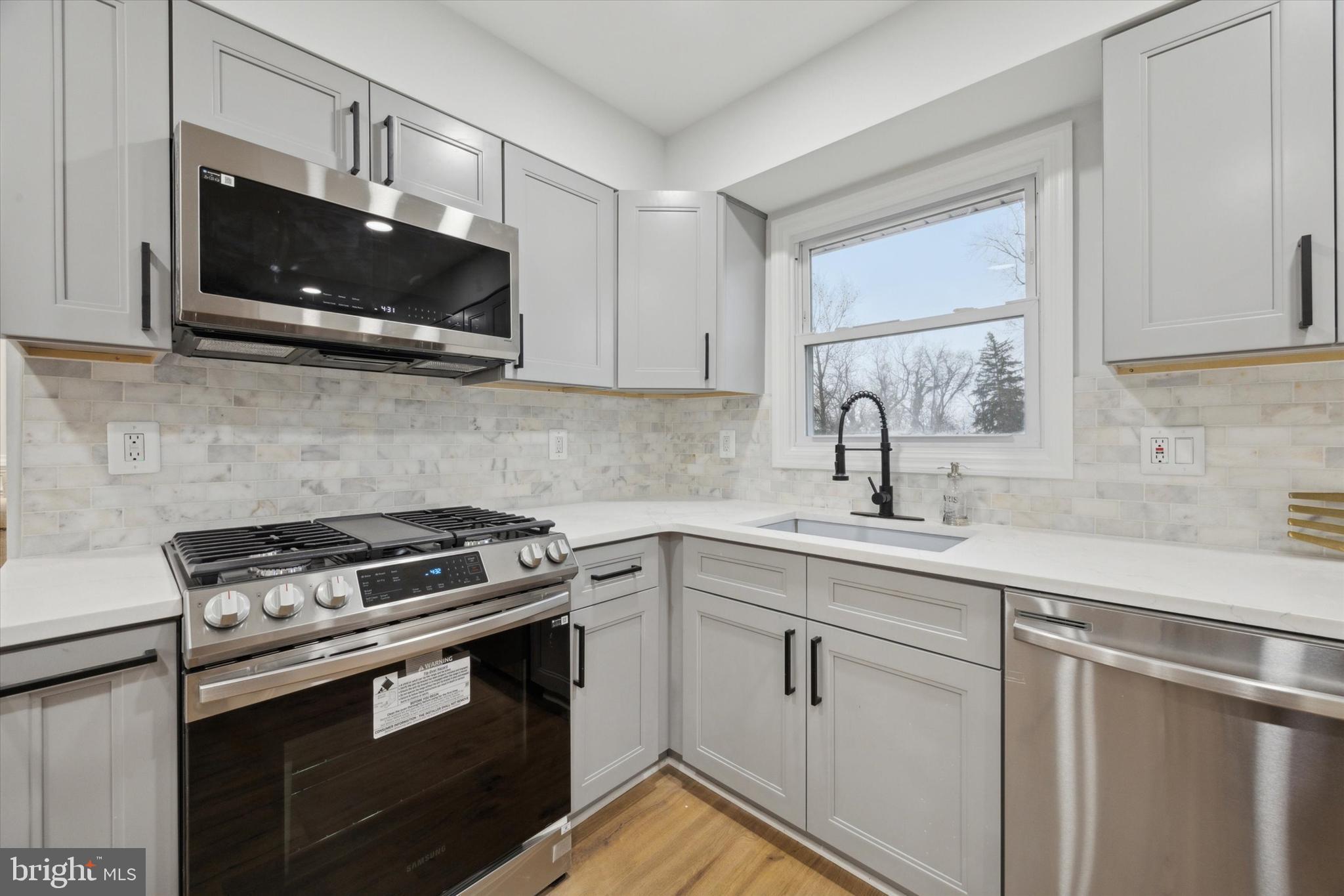 2124 Arleigh Road Cinnaminson, NJ 08077 - Photo 10 of 31 a kitchen with stainless steel appliances granite countertop a sink a stove a microwave oven and cabinets