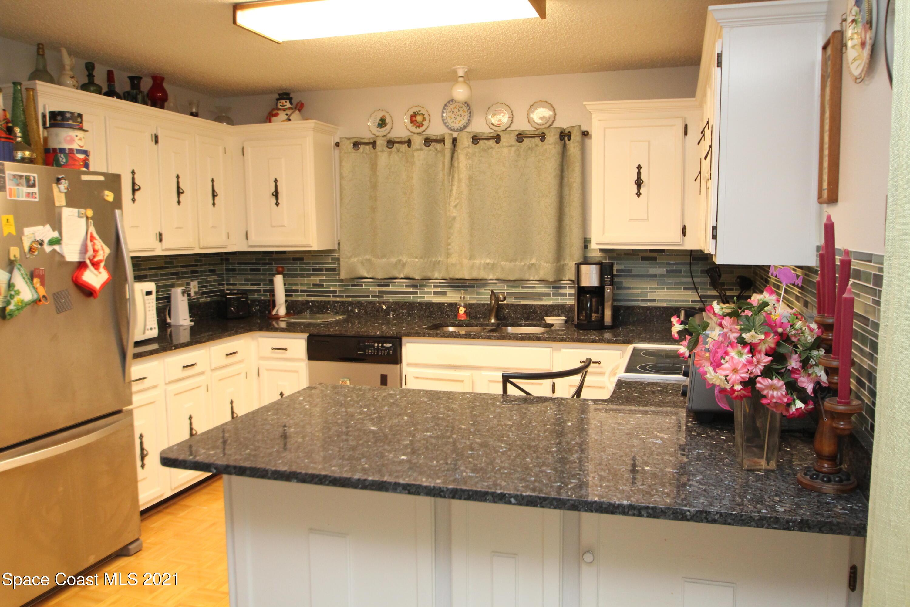 1691 Avery Road Northeast Palm Bay, FL 32905 - Photo 3 of 20 a kitchen with stainless steel appliances granite countertop a sink stove and refrigerator