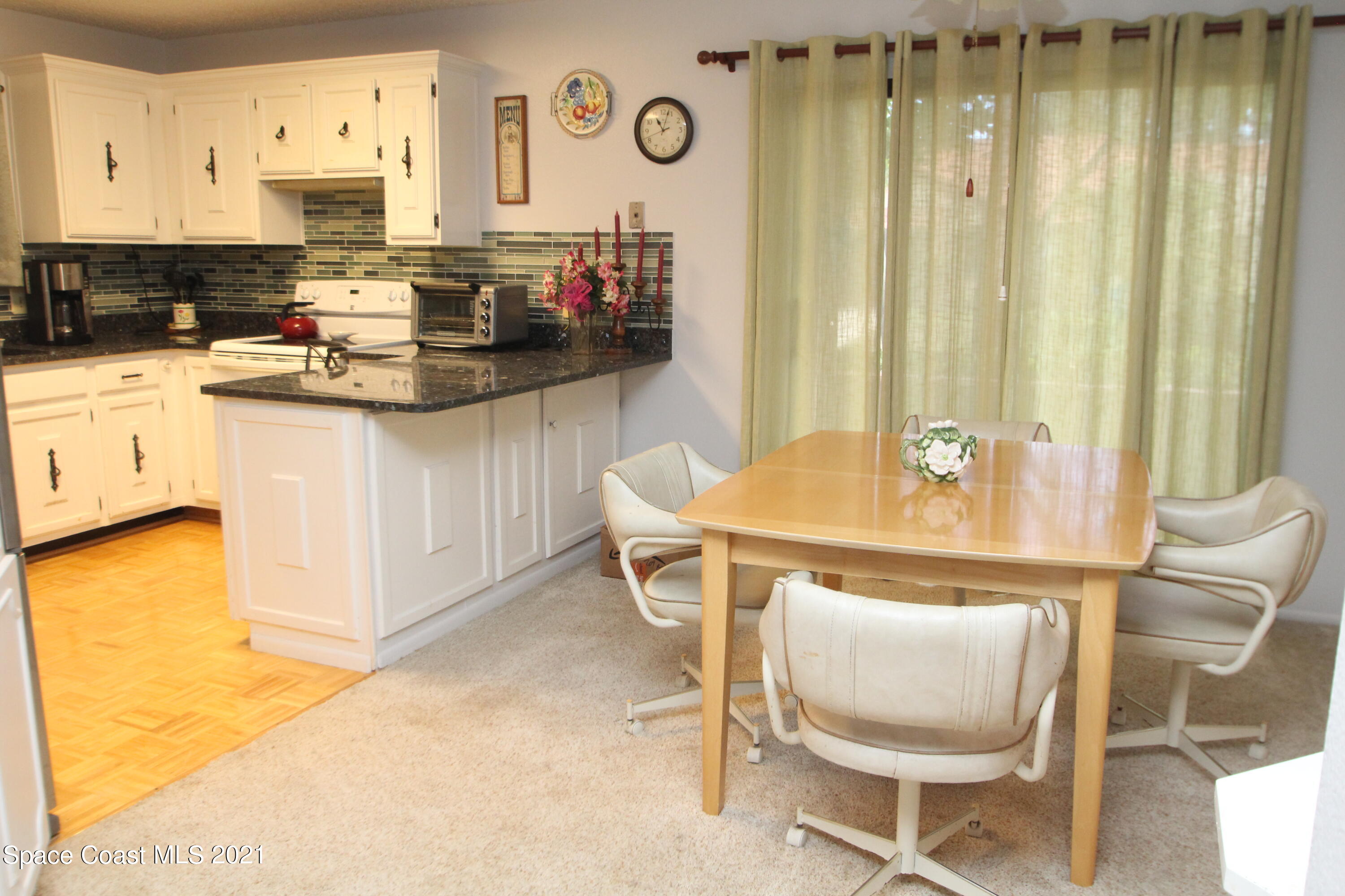 1691 Avery Road Northeast Palm Bay, FL 32905 - Photo 4 of 20 a kitchen with a table chairs stove and cabinets