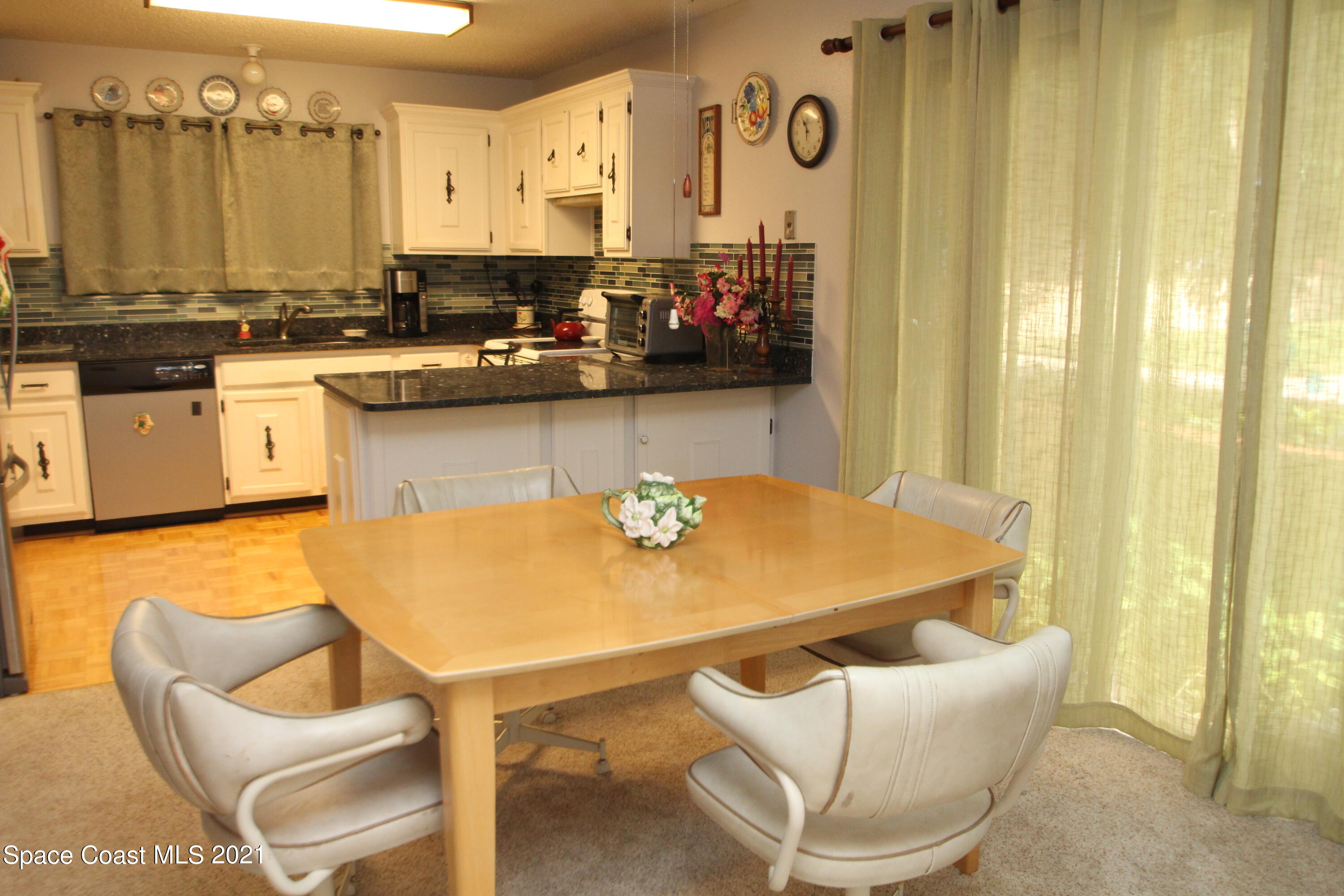 1691 Avery Road Northeast Palm Bay, FL 32905 - Photo 5 of 20 a kitchen with a table chairs and a refrigerator