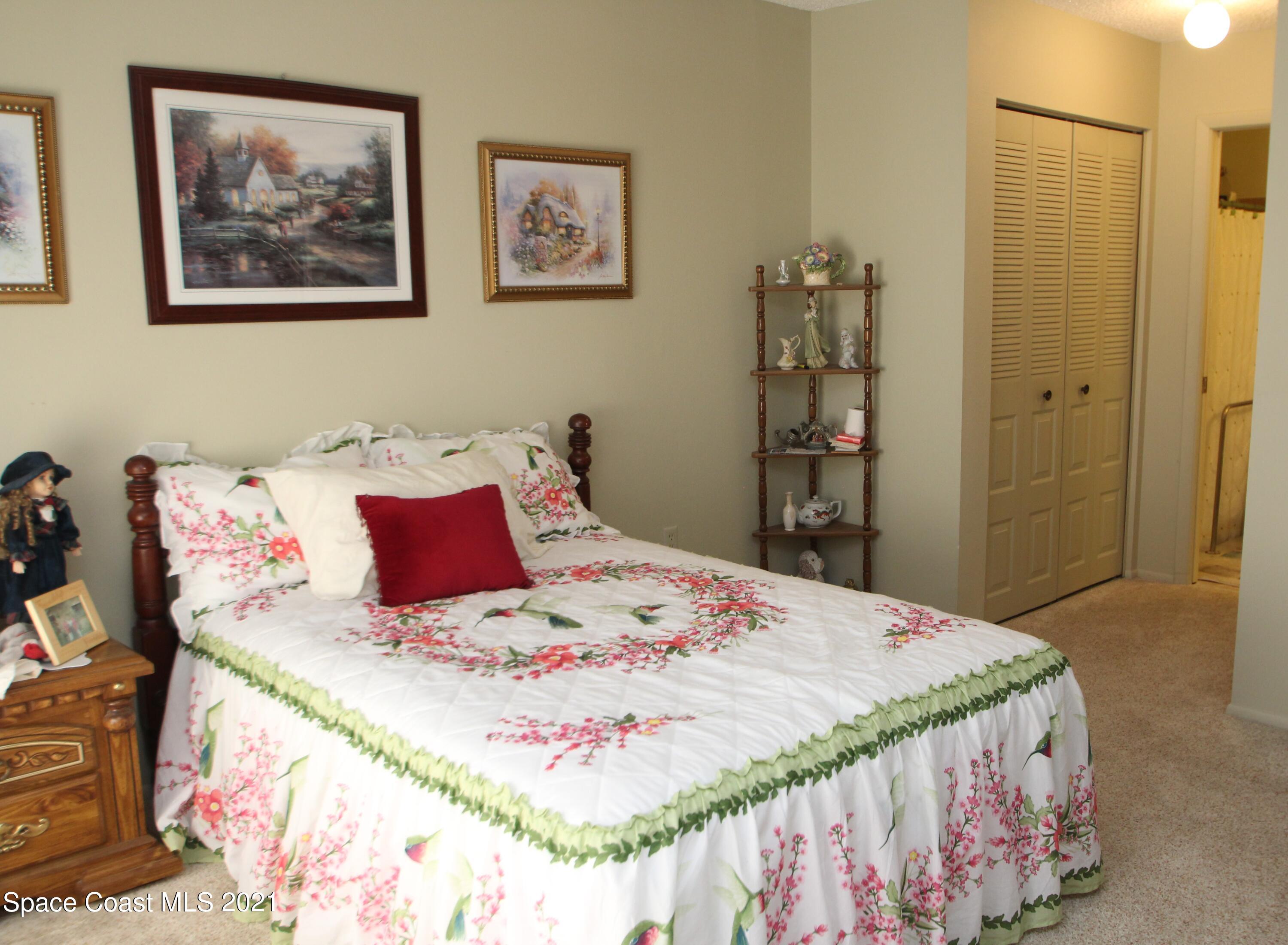 1691 Avery Road Northeast Palm Bay, FL 32905 - Photo 8 of 20 a bedroom with a bed and a painting on the wall