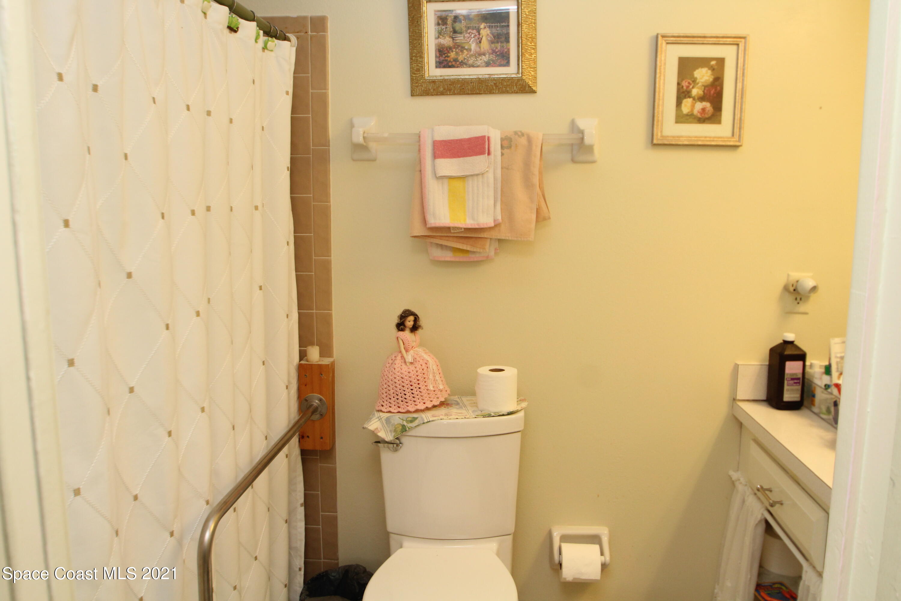 1691 Avery Road Northeast Palm Bay, FL 32905 - Photo 10 of 20 a bathroom with a toilet sink and mirror