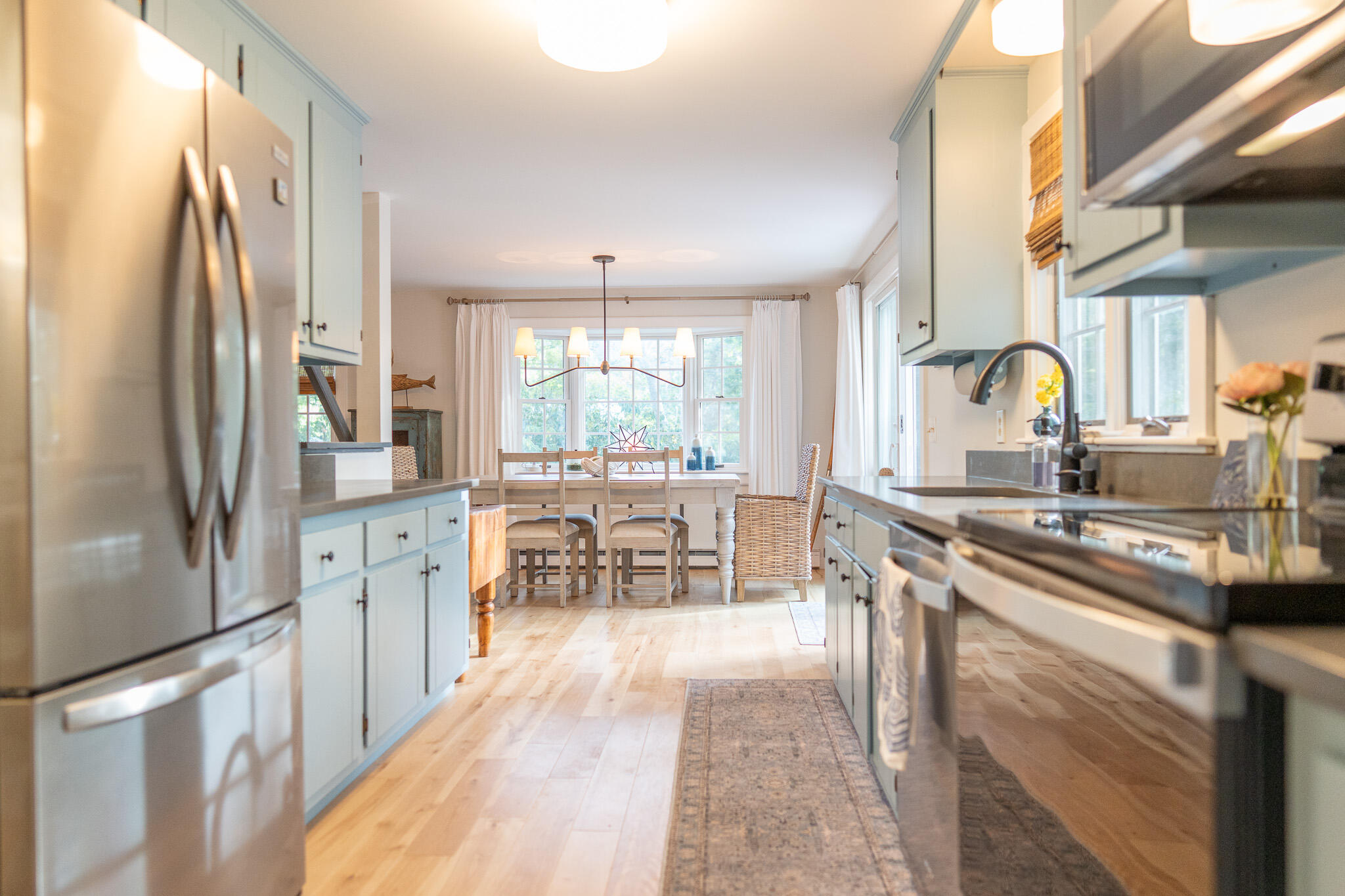 230 Massasoit Trail Eastham, MA 02642 - Photo 17 of 64 a kitchen with stainless steel appliances granite countertop a refrigerator a sink a stove and white cabinets with wooden floor