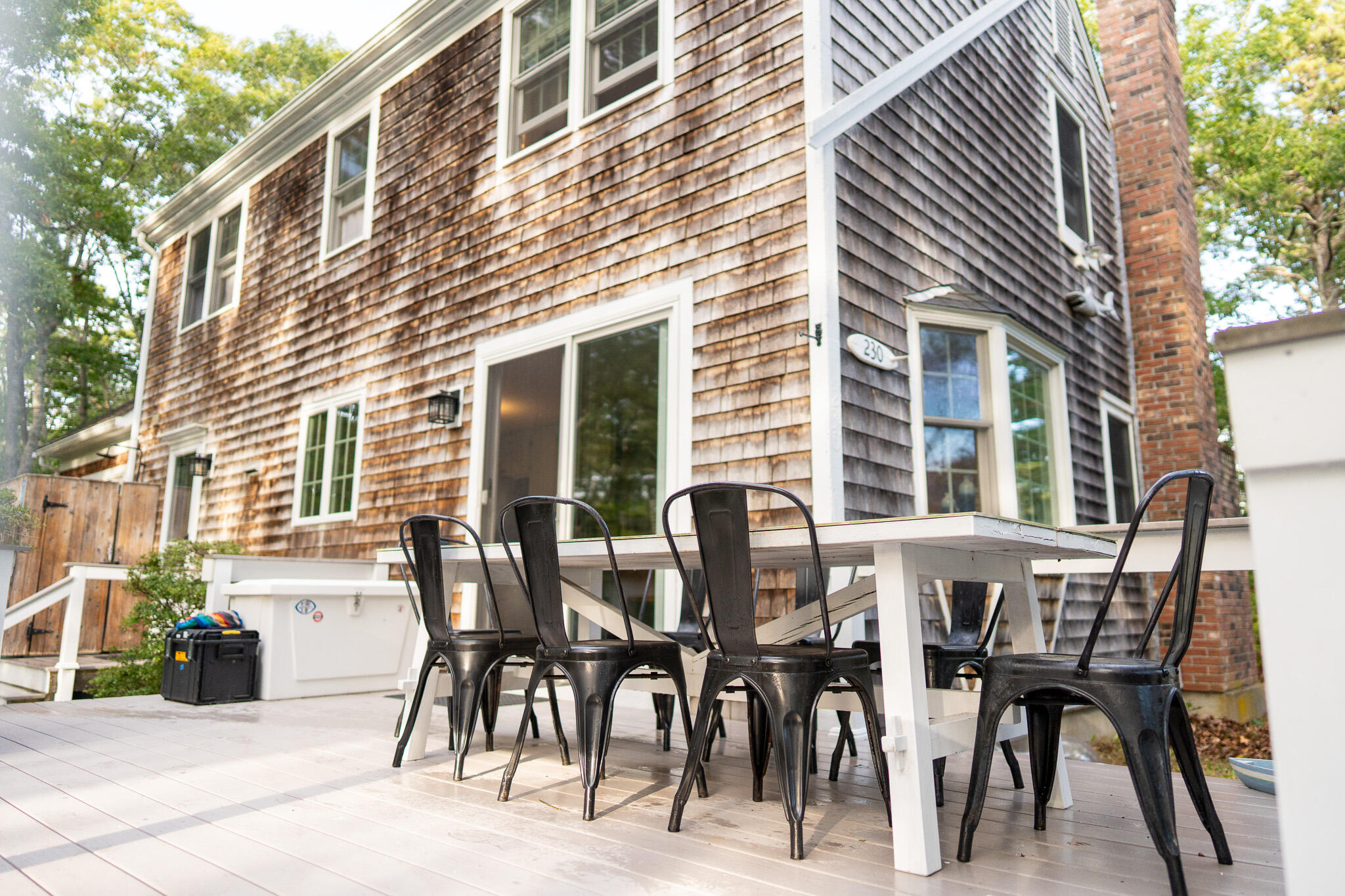 230 Massasoit Trail Eastham, MA 02642 - Photo 58 of 64 a view of a patio with table and chairs and floor to ceiling window