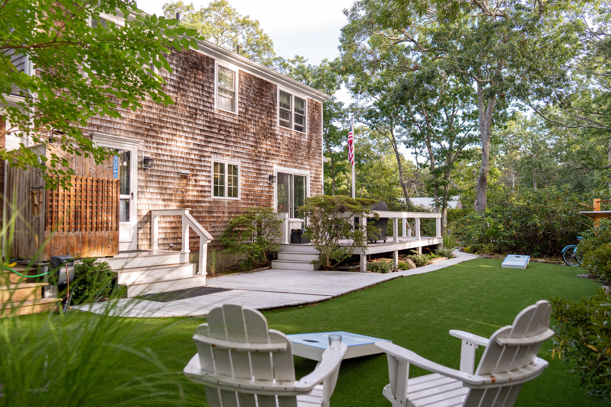 230 Massasoit Trail Eastham, MA 02642 - Photo 6 of 64 a front view of a house with a yard table and chairs