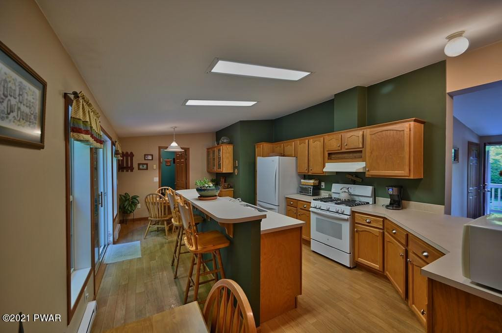 417 Northgate Road Lake Ariel, PA 18436 - Photo 13 of 91 a kitchen with stainless steel appliances granite countertop a sink a stove a refrigerator cabinets and living room view