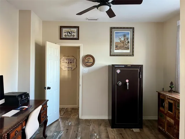 a view of a livingroom with a ceiling fan and wooden floor