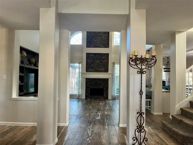 a view of a livingroom with wooden floor and a fireplace
