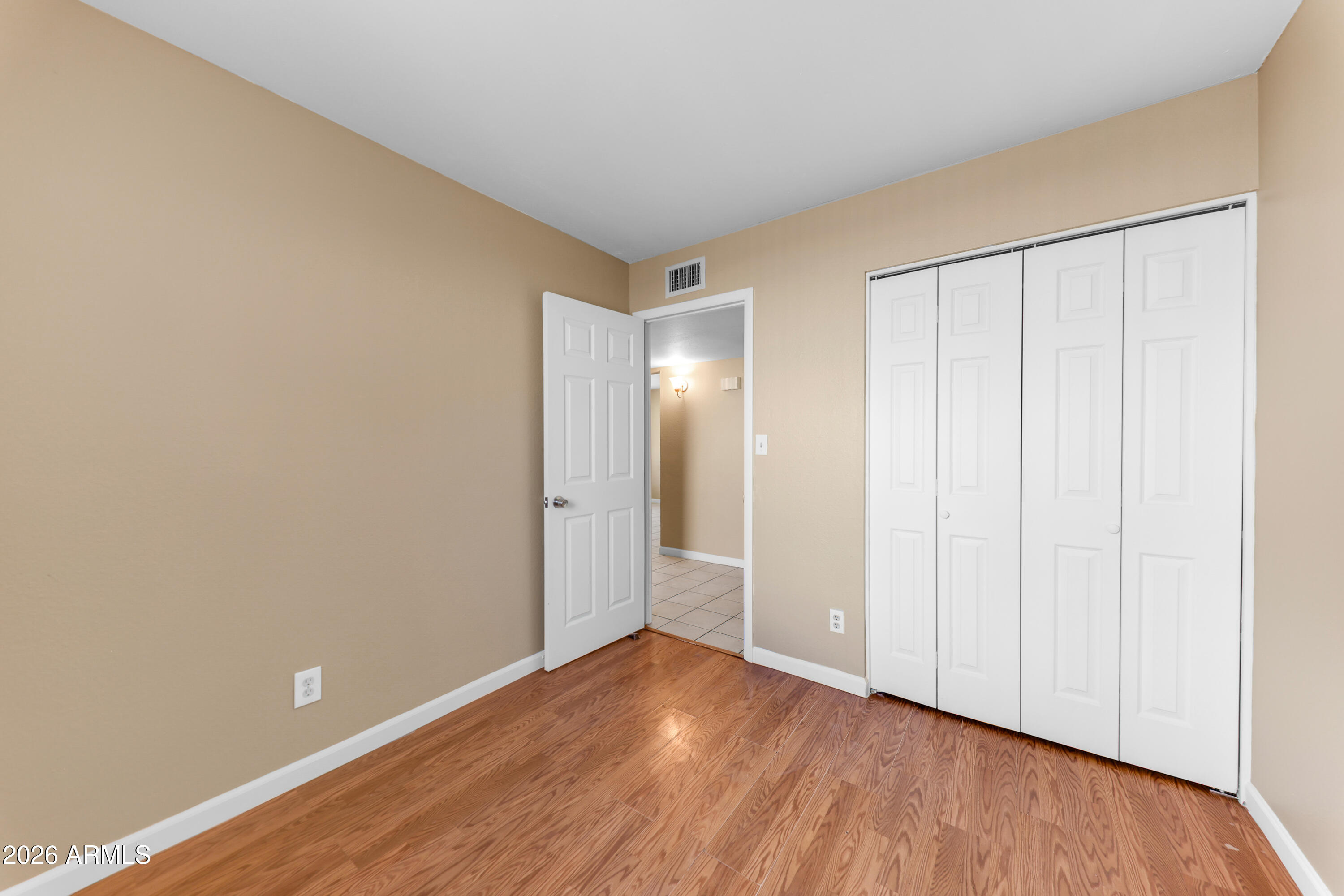 4723 East Vineyard Road Phoenix, AZ 85042 - Photo 20 of 27 a view of an empty room with wooden floor